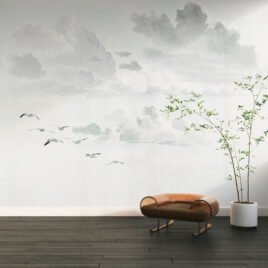 Delicata carta da parati denominata Effimera Eternità che raffigura un cielo ampio e nuvoloso in stile acquerello, attraversato da uno stormo di uccelli bianchi che volano leggeri verso l'orizzonte.