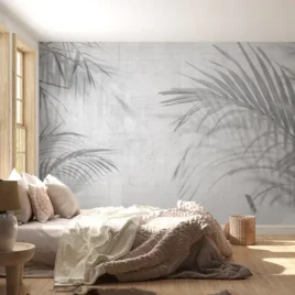 Ombre di palme si proiettano su una superficie tessile, creando un’atmosfera luminosa e silenziosa.